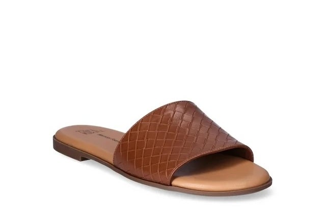 A brown, crocodile-embossed slide sandal displayed against a white background