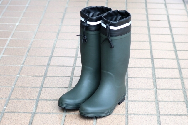 ゴム製の長靴がタイル張りの地面に置かれています。