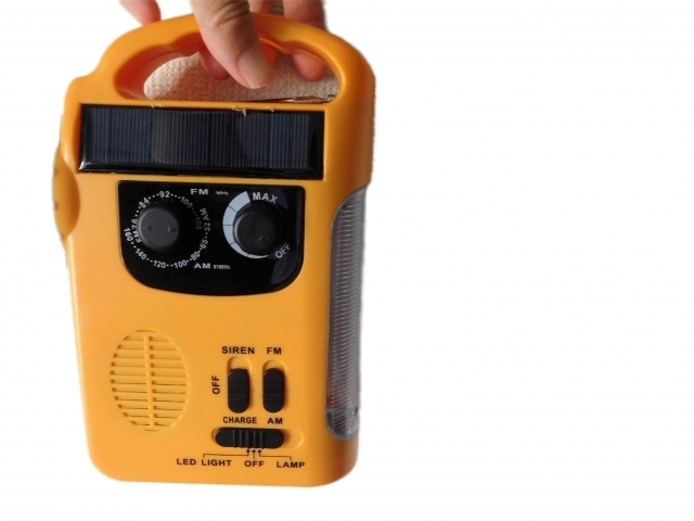 手で持っている手回し充電式ラジオ