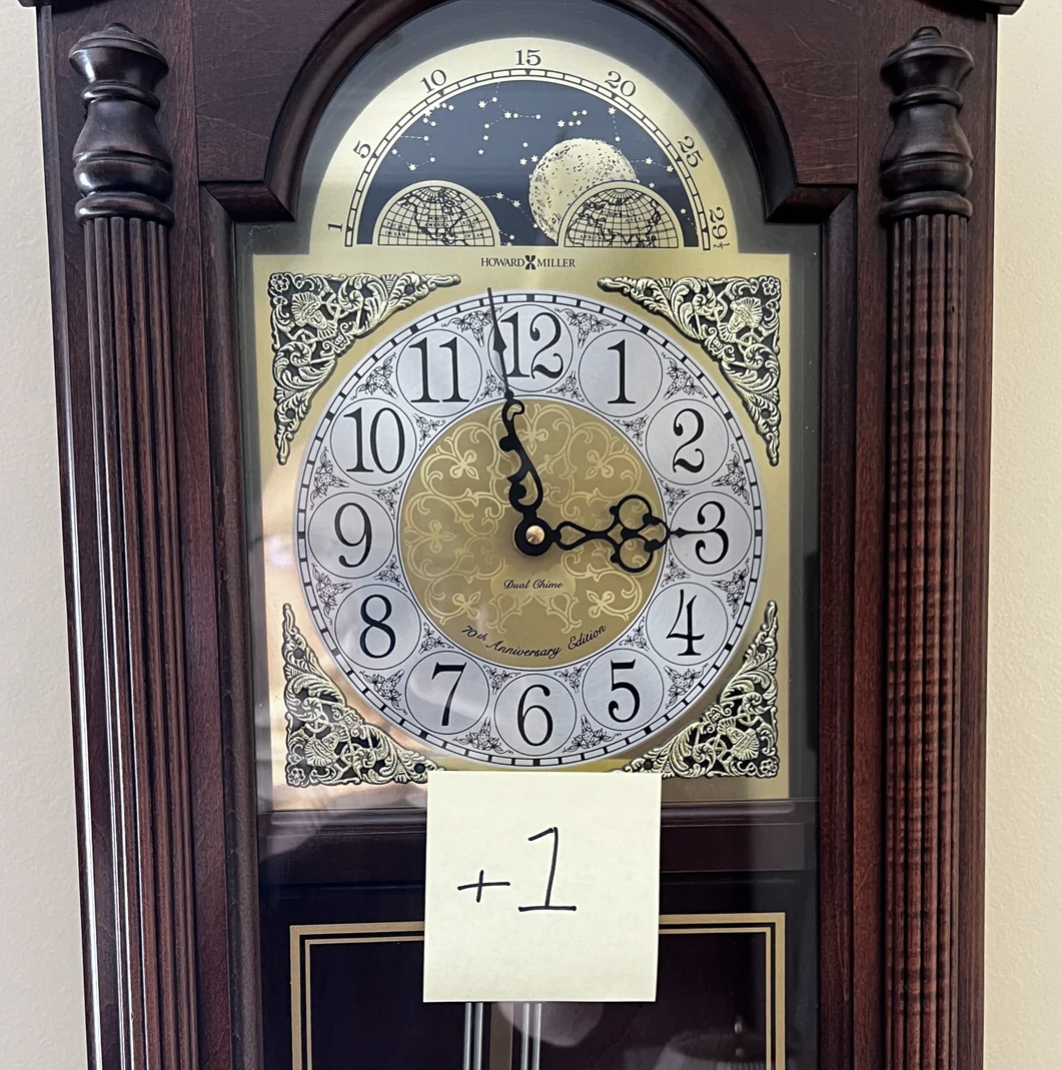 Grandfather clock with a note saying &quot;+1&quot; indicating a time change reminder