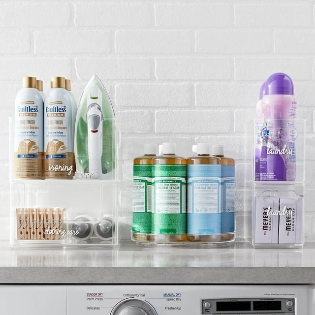 Laundry products organized in bins on a shelf above a washing machine
