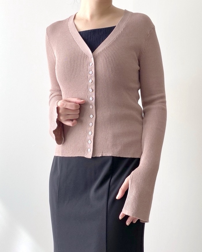 Person wearing a ribbed button-up cardigan and skirt, head not shown