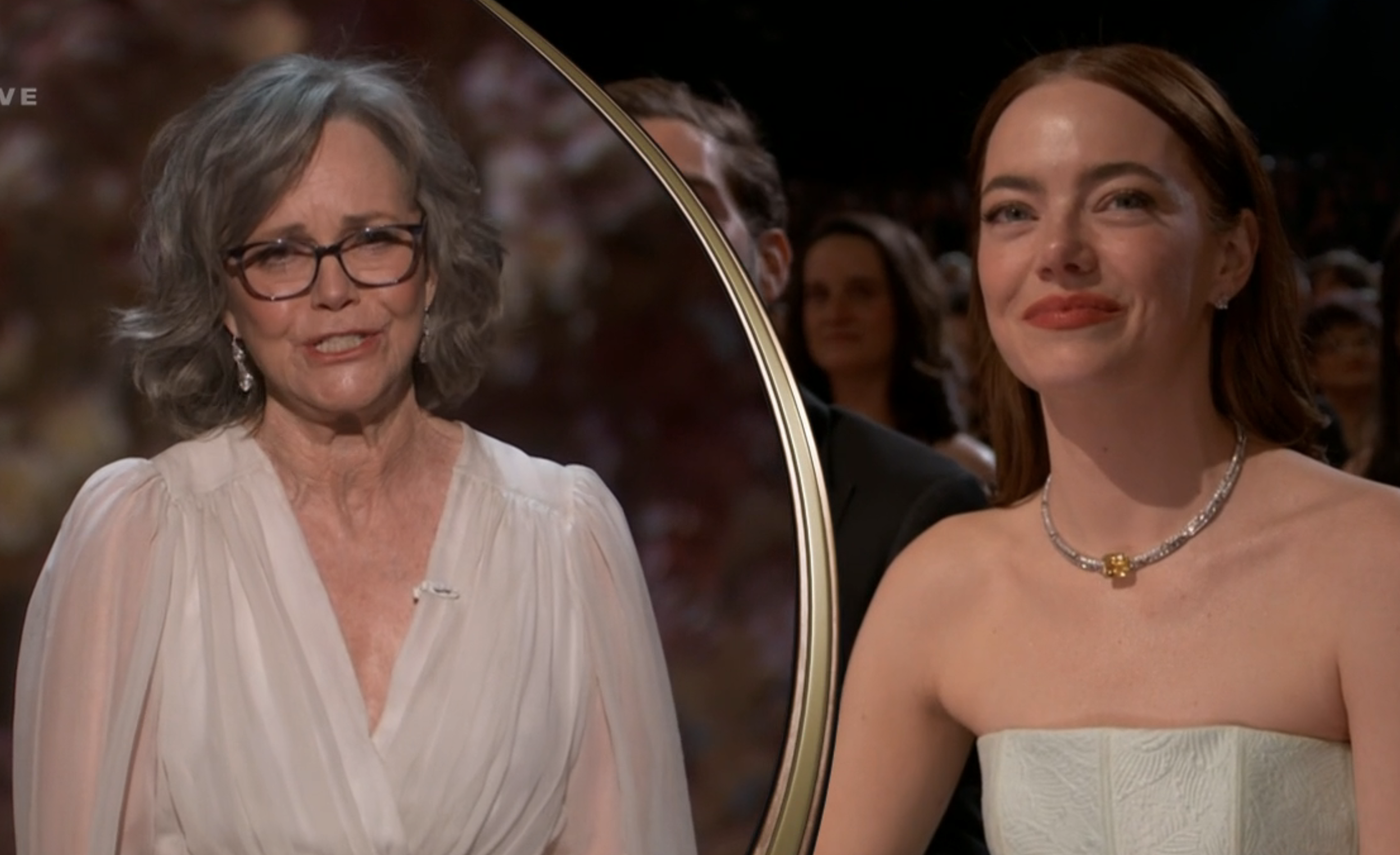 Sally Field and Emma Stone smiling as they look at one another during the presentation