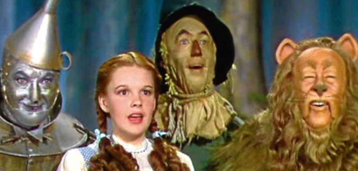 Dorothy and her companions, the Tin Man, Scarecrow, and Cowardly Lion, stand together in &#x27;The Wizard of Oz.&#x27;