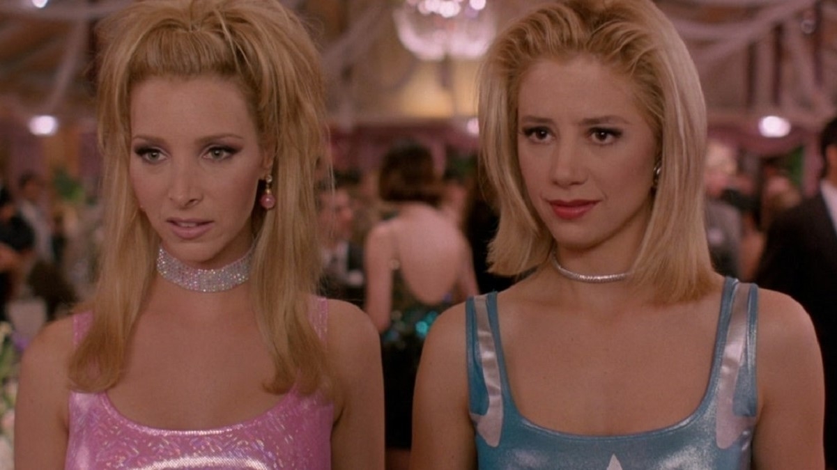 Two women from the film &#x27;Romy and Michele&#x27;s High School Reunion&#x27; in shiny, pastel-toned dresses at a party