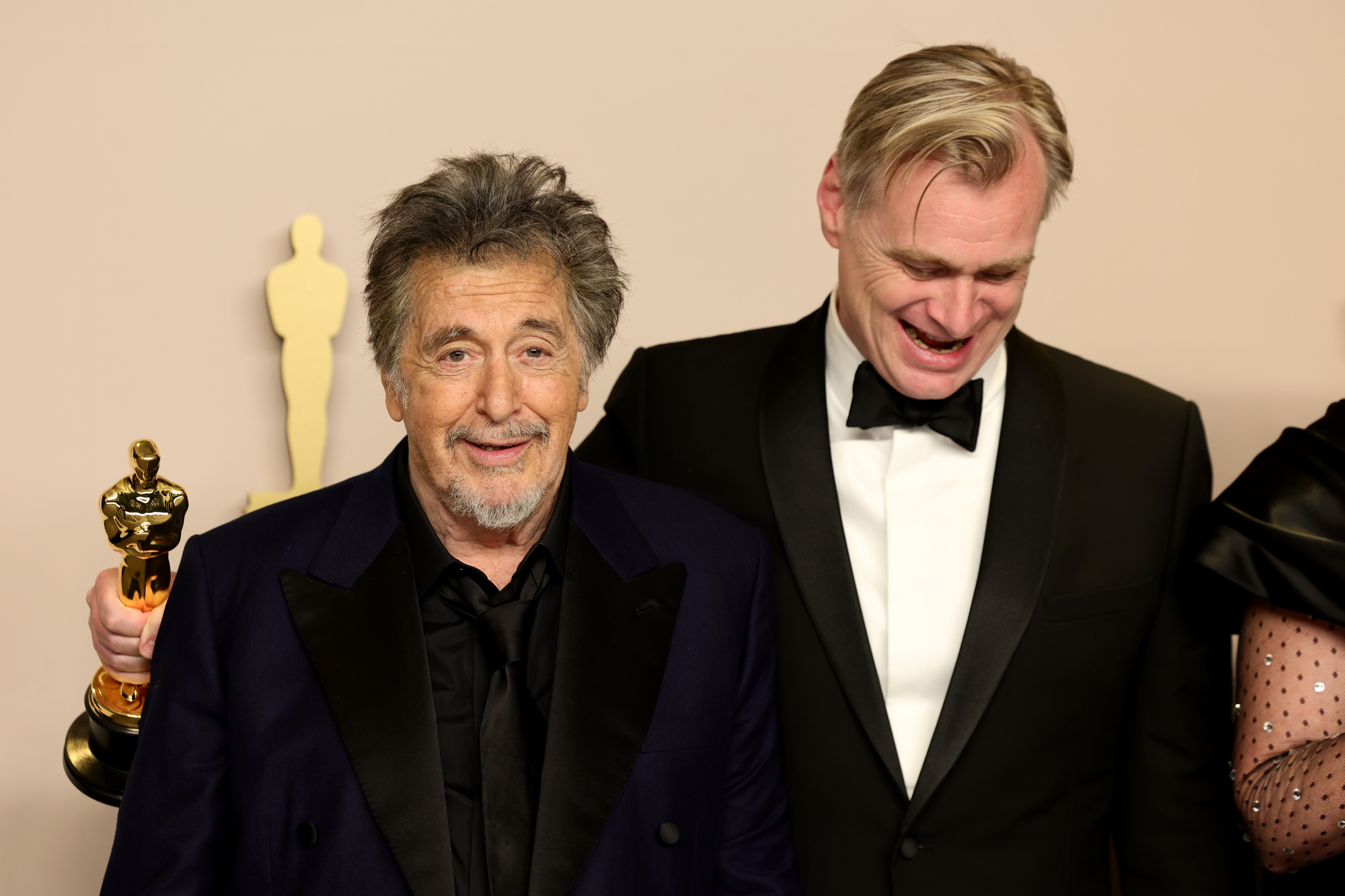 Al Pacino and Christopher Nolan smiling, Nolan holds an award, backstage at the Oscars
