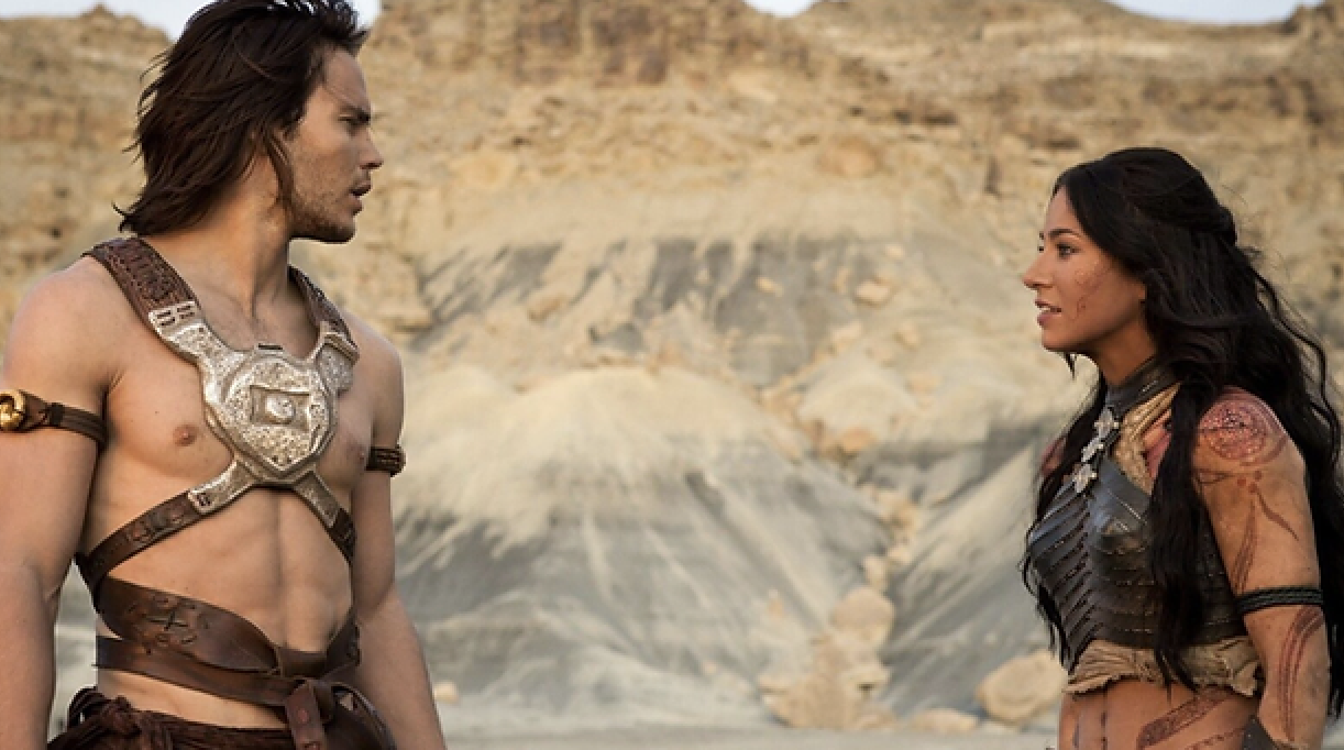 Two characters in fantasy warrior attire face each other in a desert setting
