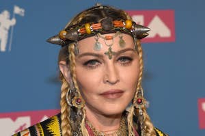 Madonna wearing a jacket and accessorized with layered necklaces and headpiece