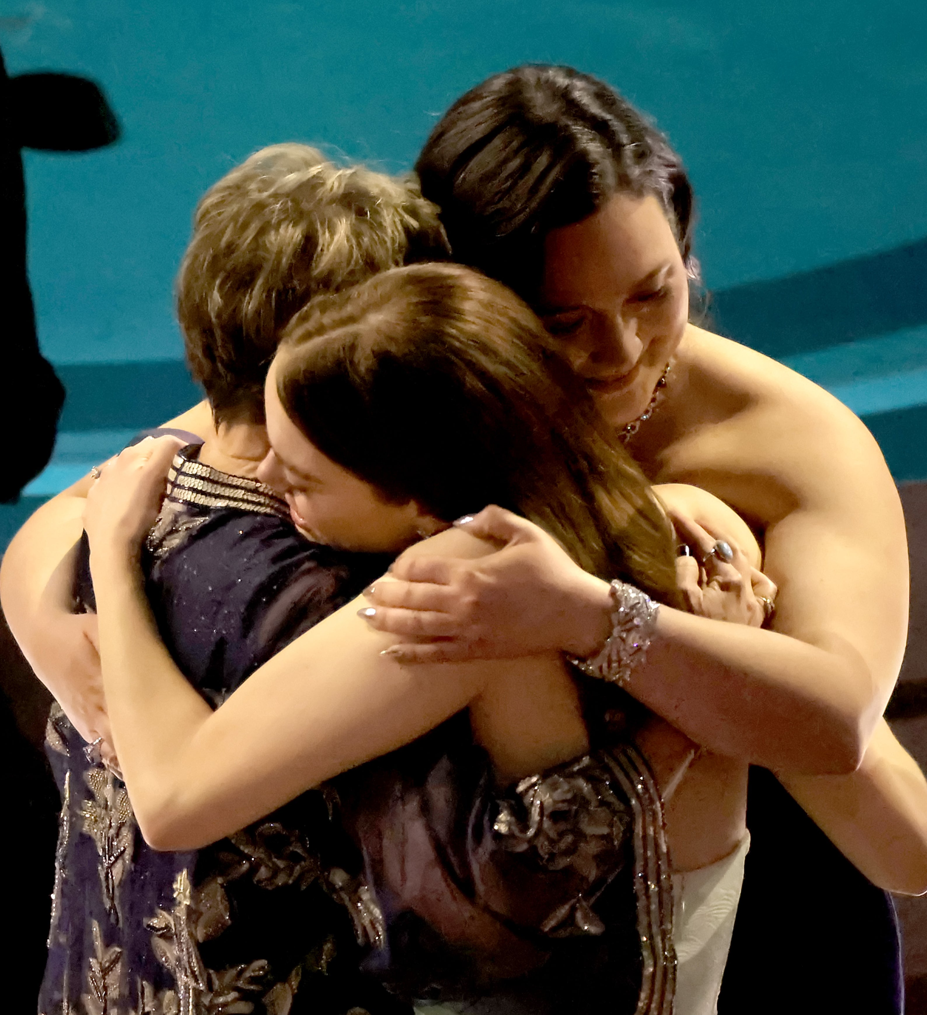 Annette Bening, Emma Stone, and Lily Gladstone embrace at the Oscars