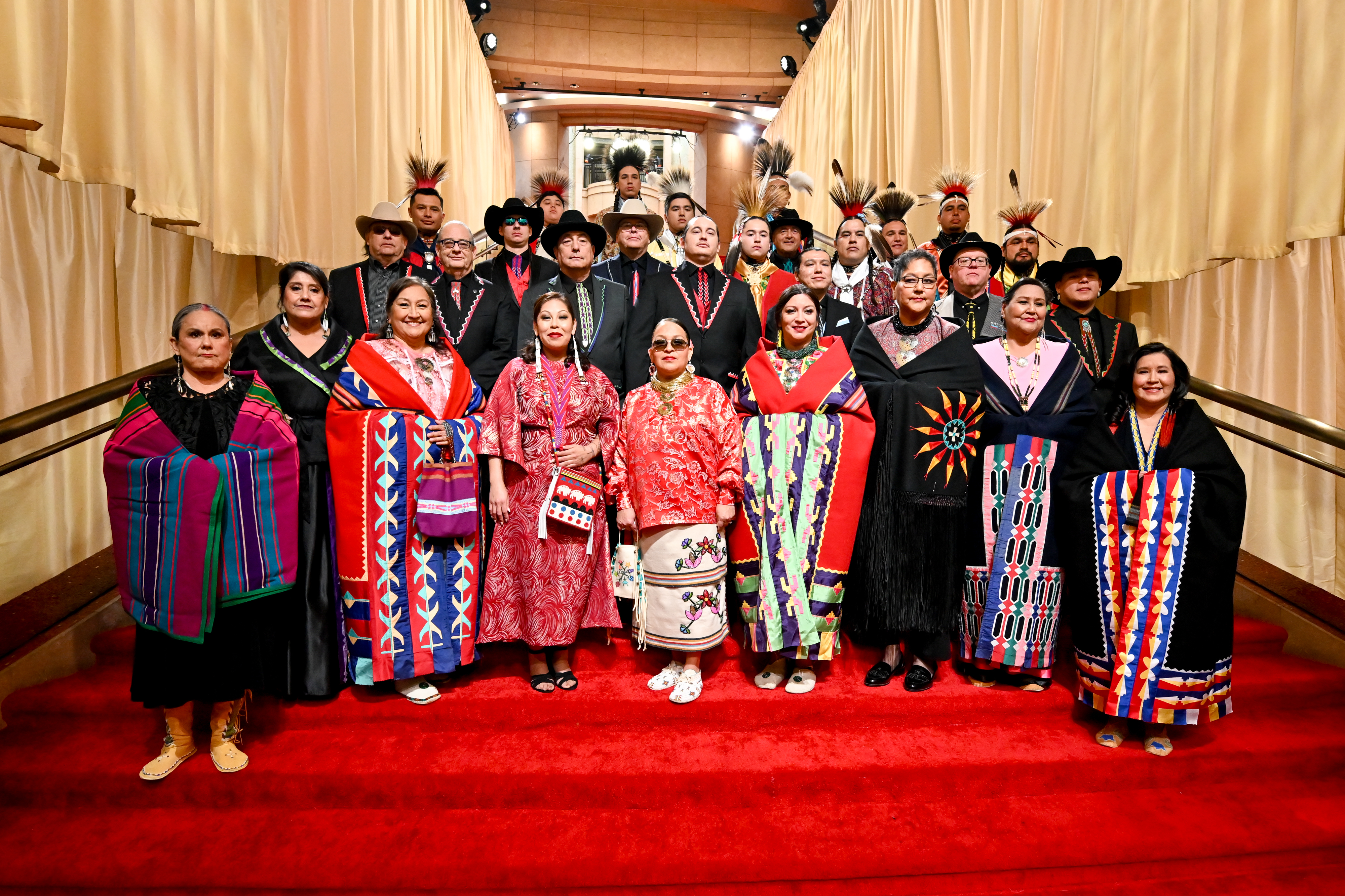 Members of the Osage Nation pose for a group photo on a set of steps at the 96th Annual Oscars
