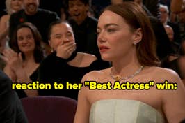 Actress in a strapless dress reacts to winning an award, audience applauding in background