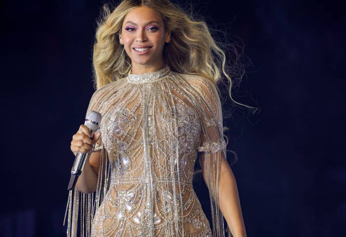 Beyoncé performing on stage in an embellished dress with a microphone in hand