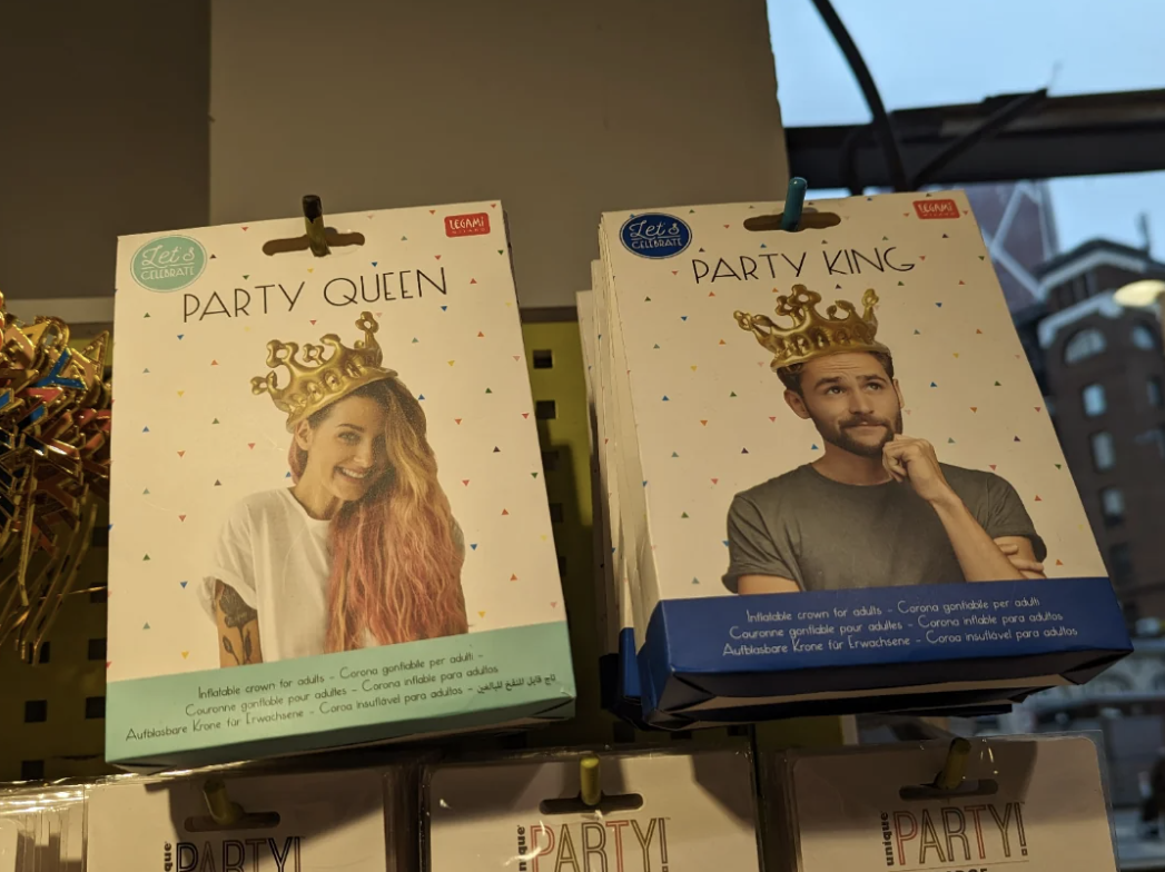 Packaging for &quot;Party Queen&quot; and &quot;Party King&quot; crowns with smiling person on each. Text on package in various languages
