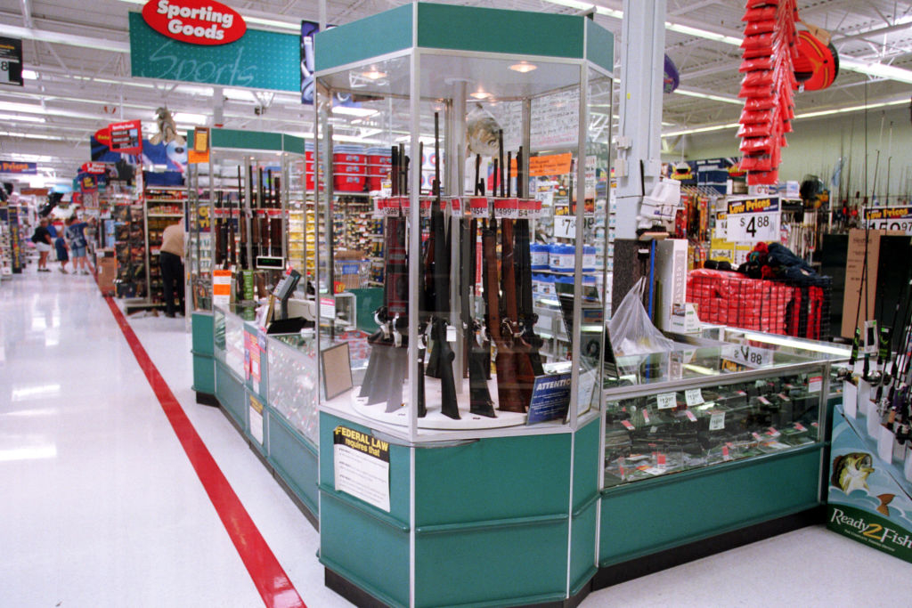Gun display case in a sporting goods section of a store with various rifles and shotguns