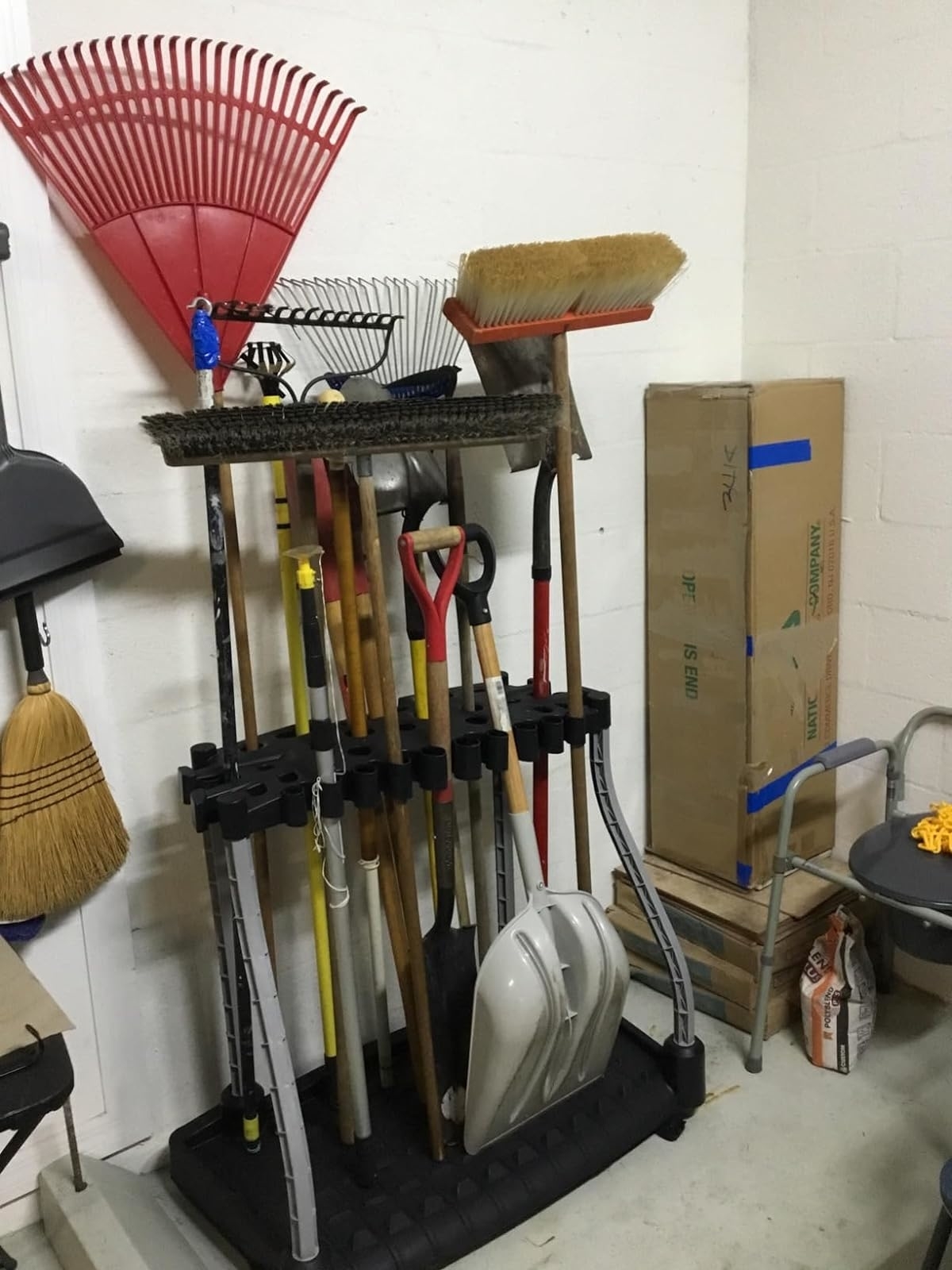 Assorted cleaning tools organized in a corner storage unit in a garage