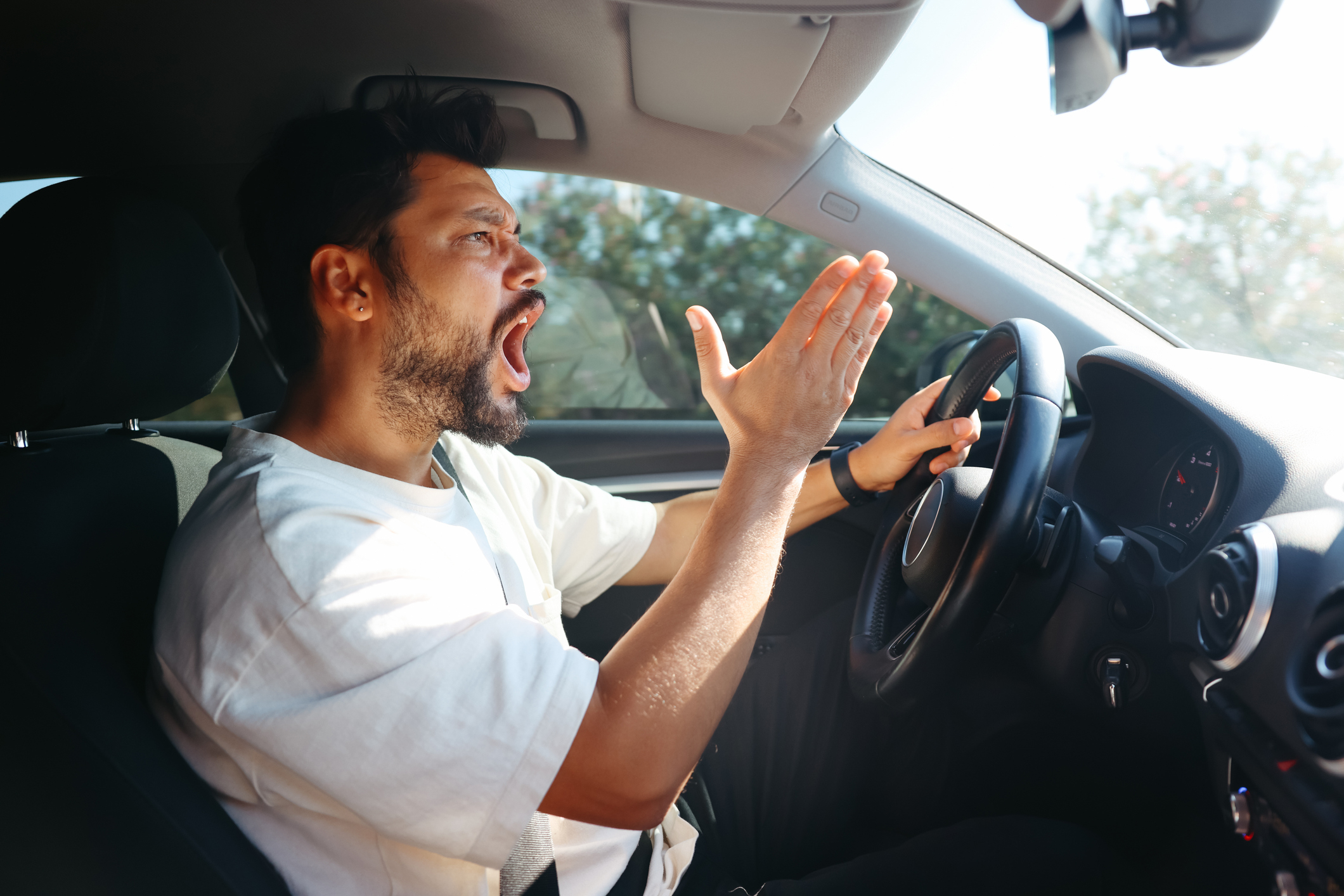 Man driving a car and gesturing angrily