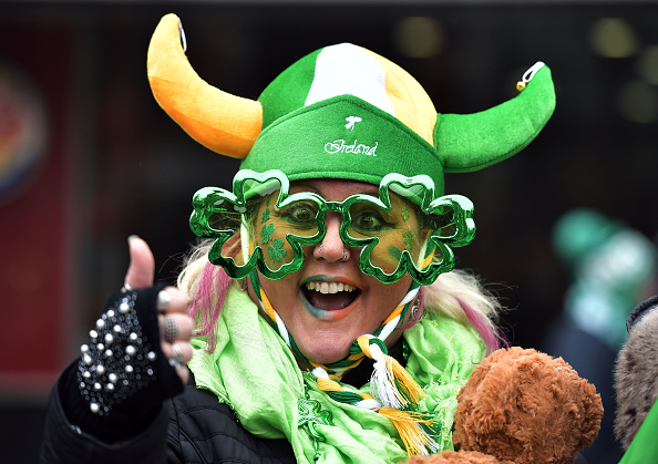 Person wearing a Viking hat and shamrock glasses celebrating St. Patrick&#x27;s Day with festive attire