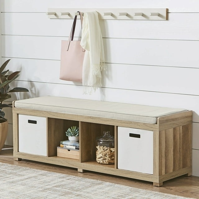 Entryway bench with a cushion, storage cubbies, and two white bins