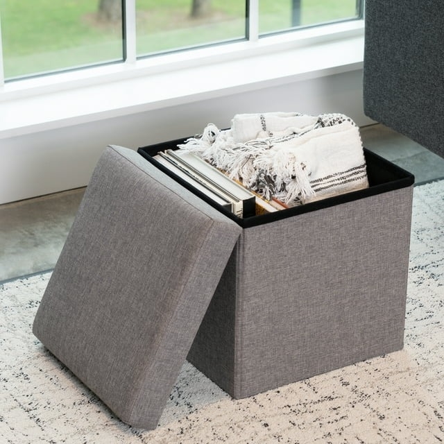 Storage ottoman open showing blankets and books inside