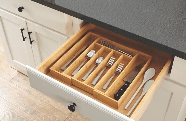 the organizer inside a kitchen drawer with organized utensils