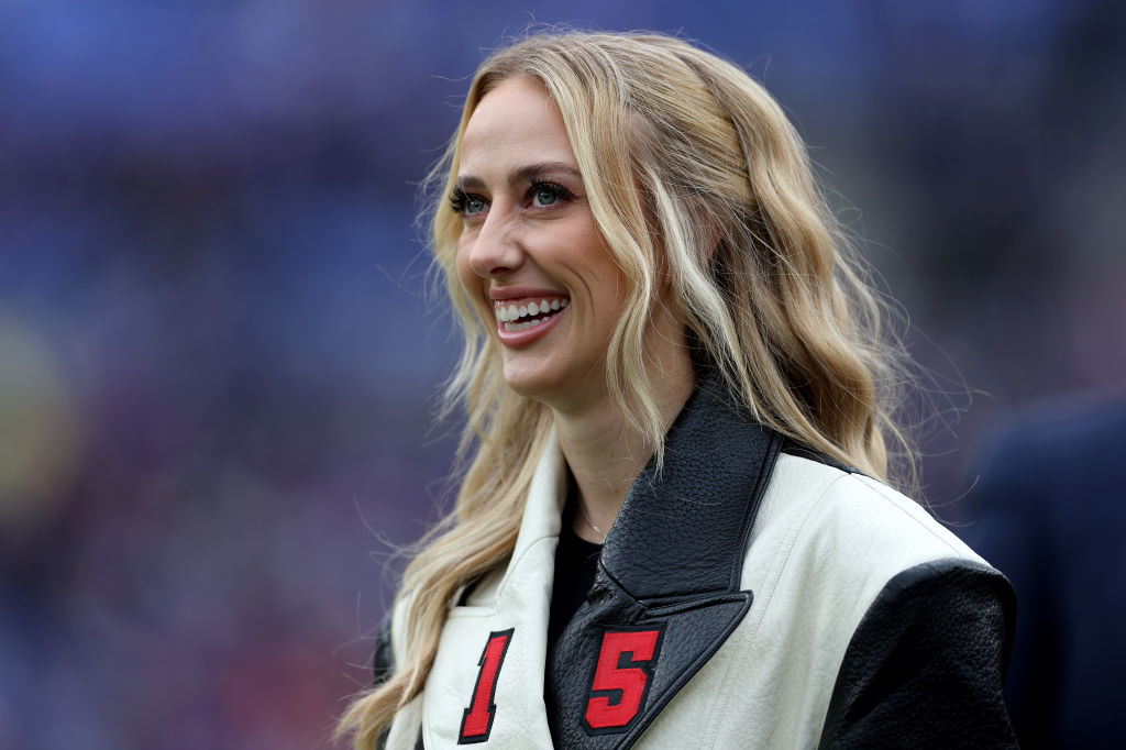 Brittany smiling wearing a jacket with &#x27;15&#x27; on it at an outdoor event