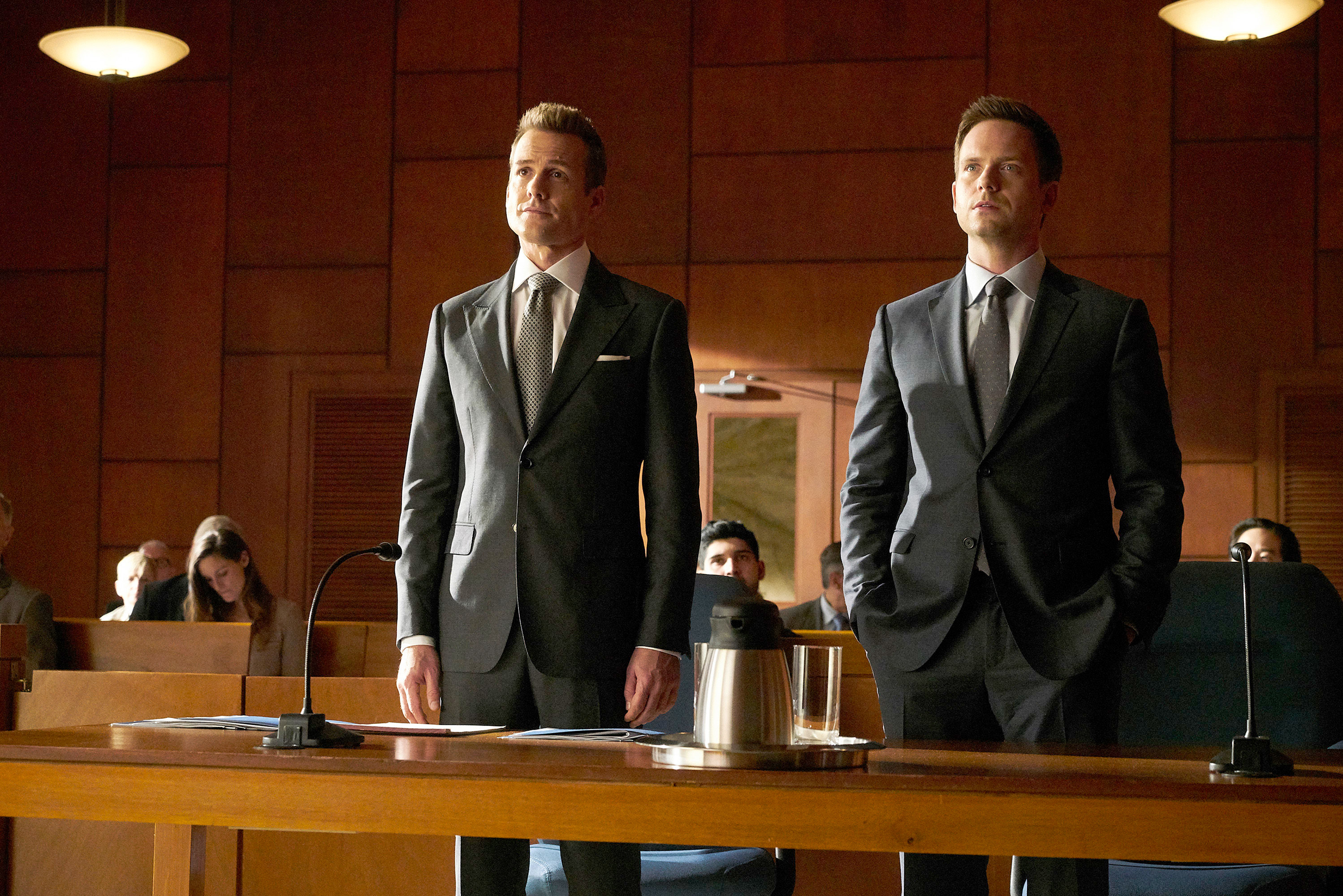 Harvey Specter and Mike Ross stand in a courtroom in a scene from Suits