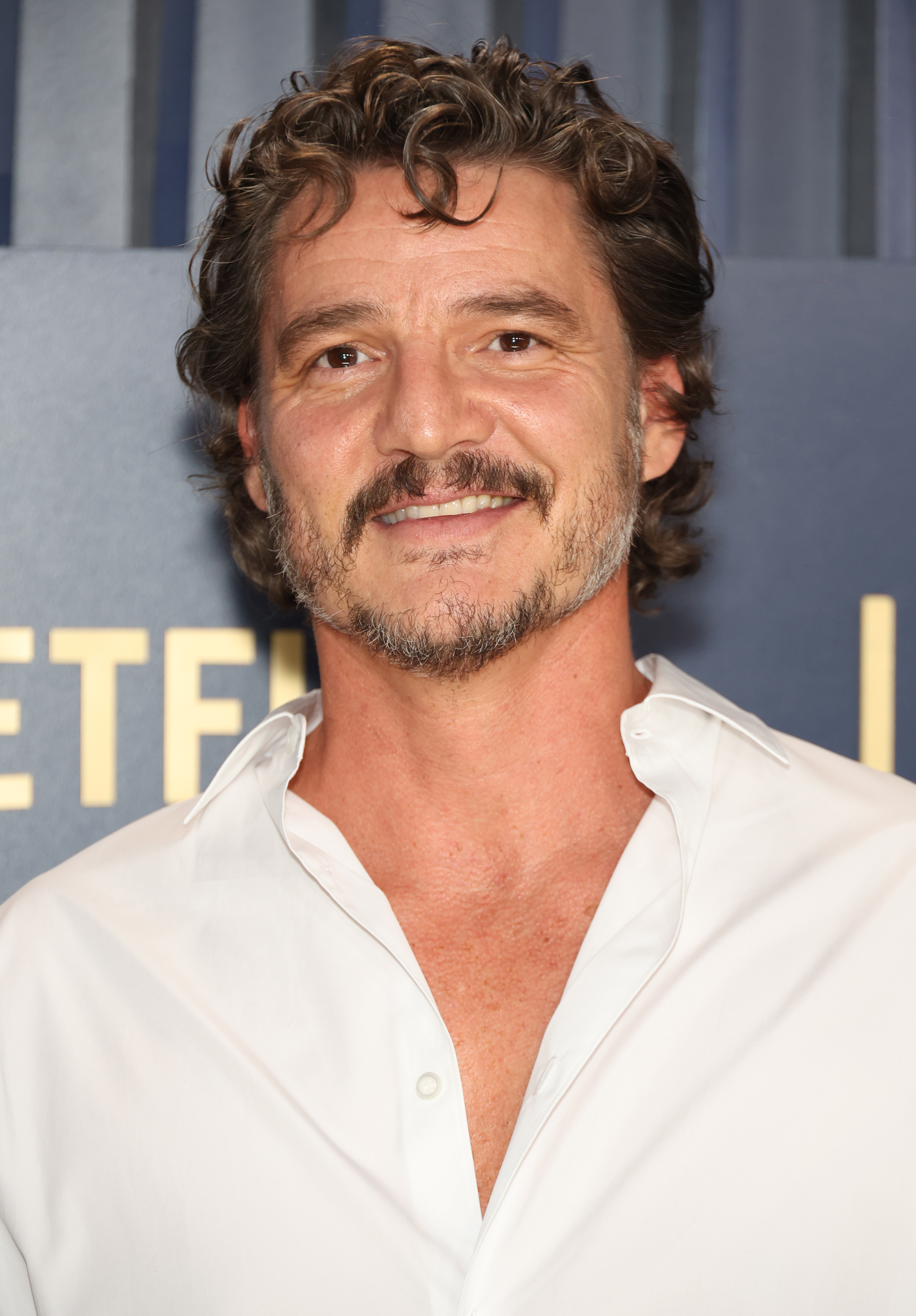 Pedro Pascal at an event, wearing a casual button-down shirt