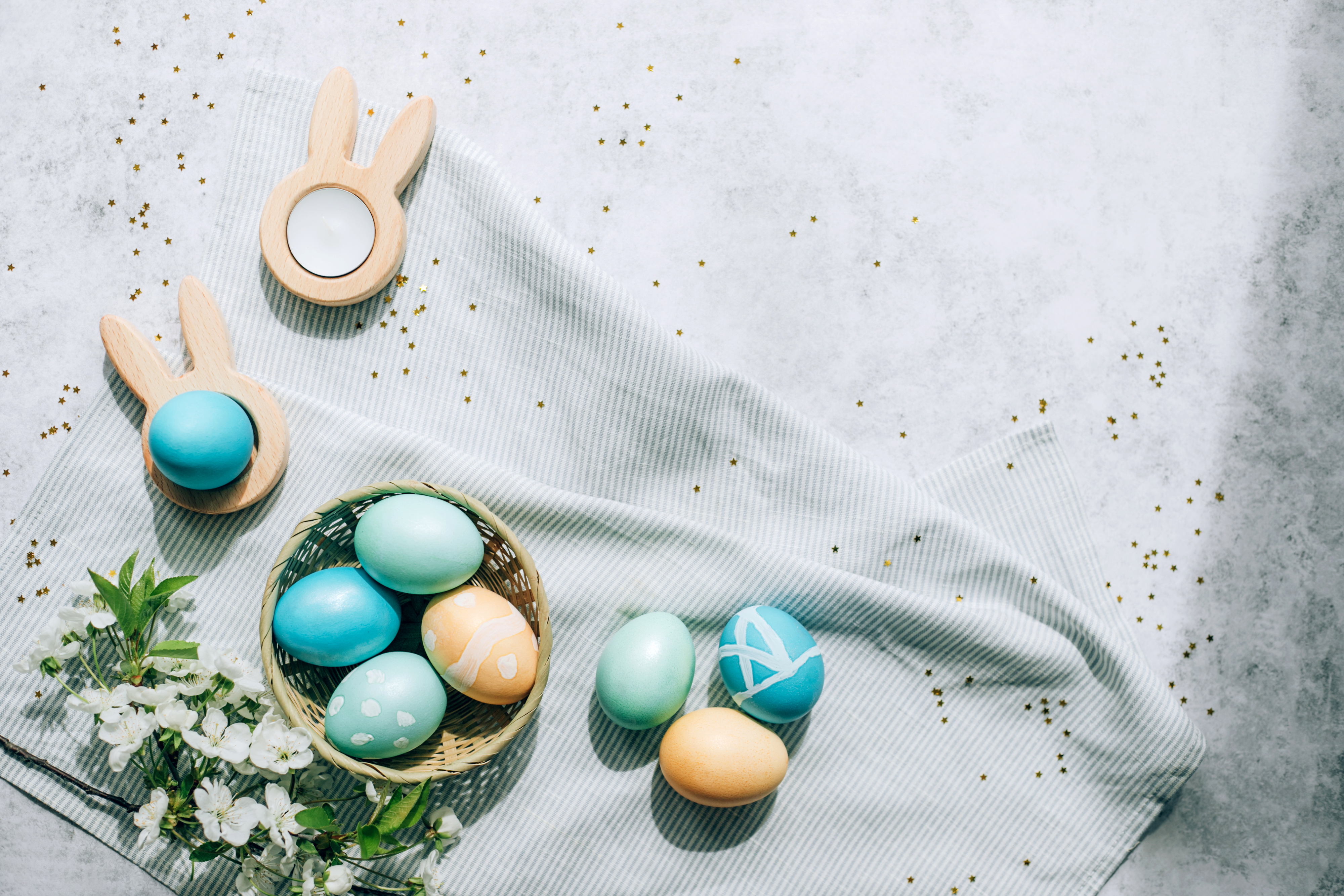 Easter composition with painted eggs, bunny decorations, and flowers on a textured background