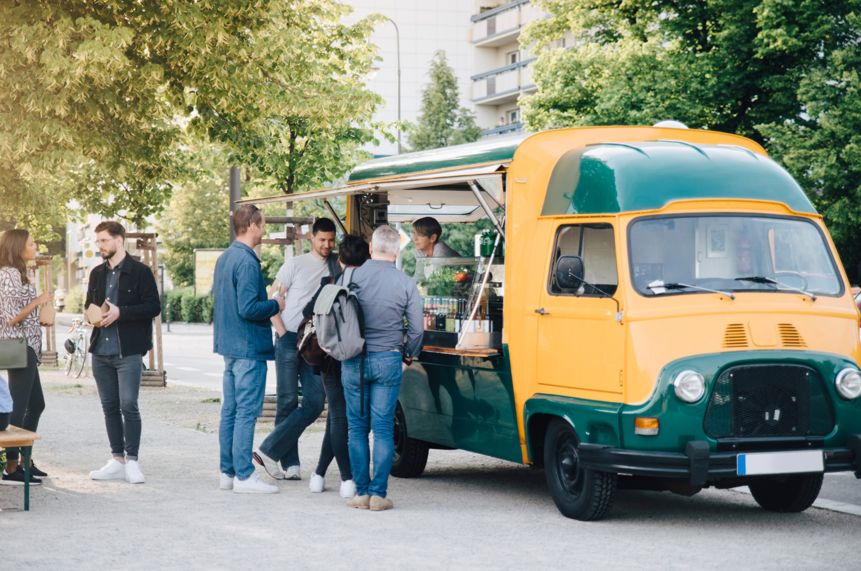 People gathered at a street food truck with a vendor serving