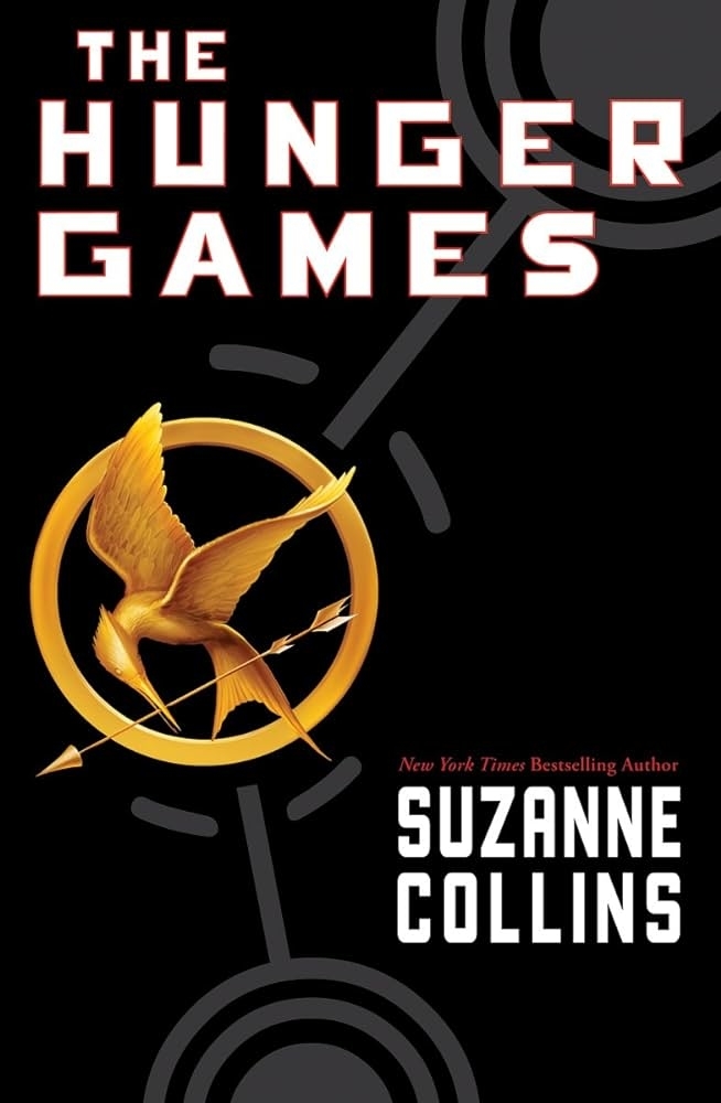 Cover of &quot;The Hunger Games&quot; by Suzanne Collins featuring a golden pin with a mockingjay