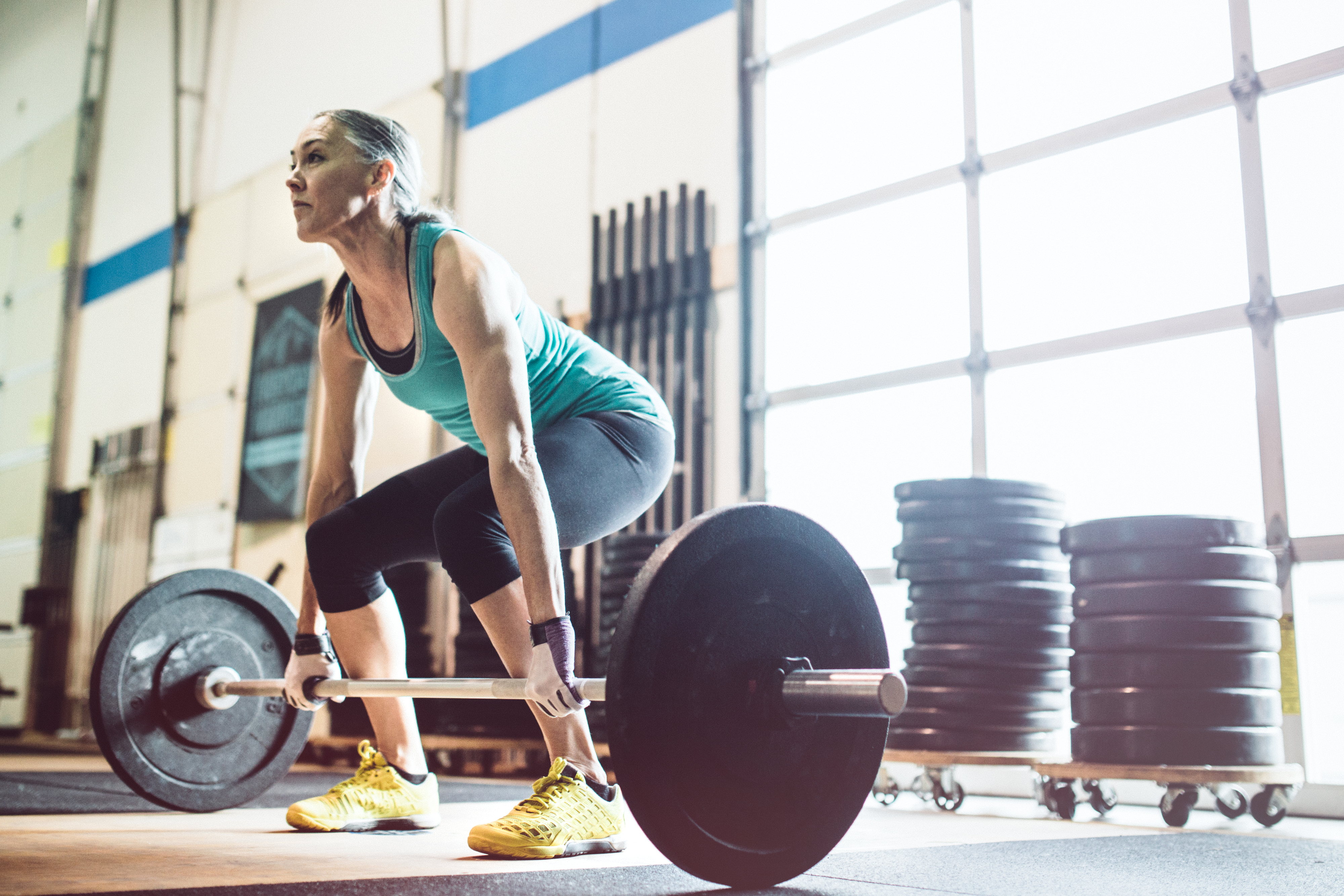 Woman prepares to lift a barbell at the gym