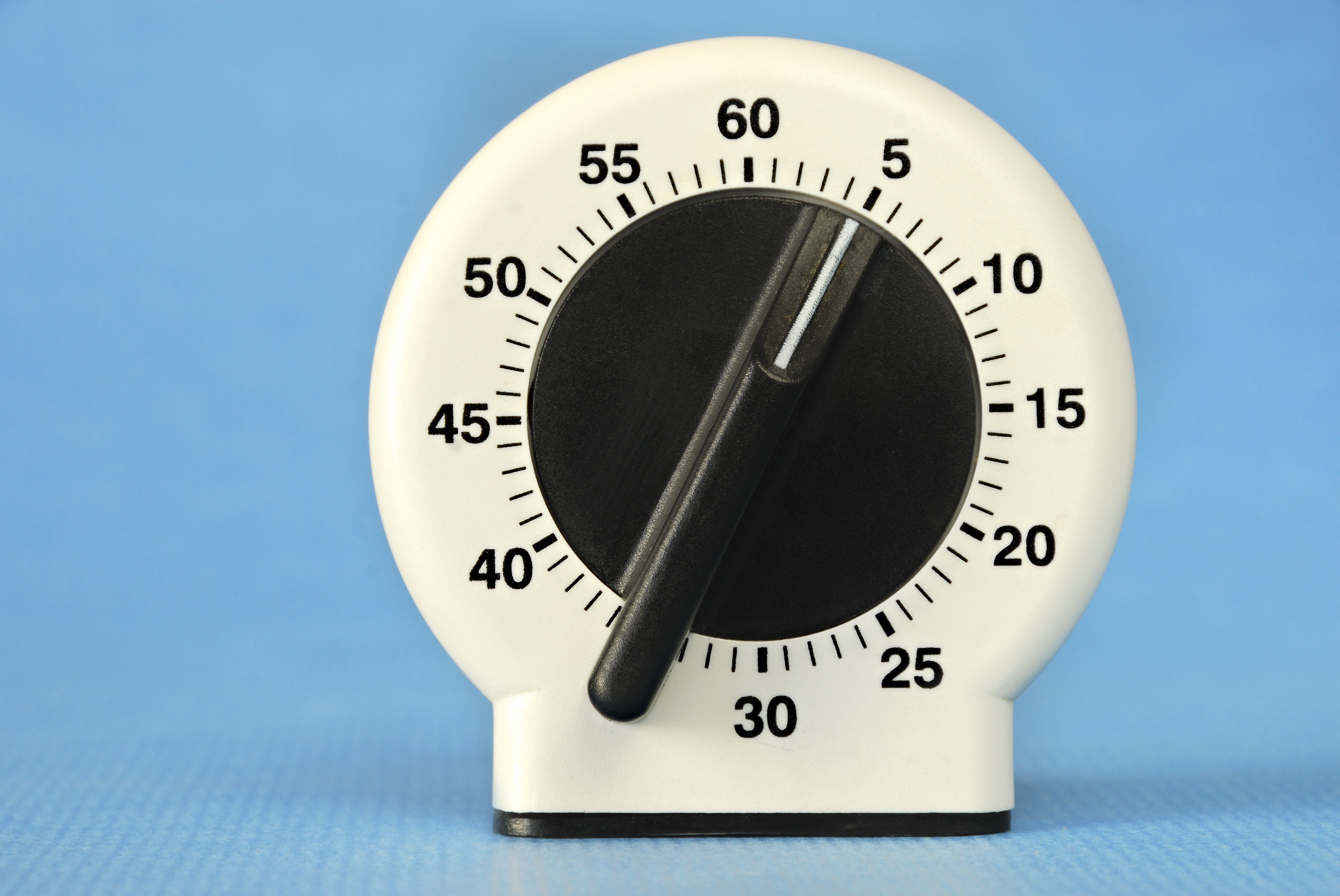 Kitchen timer set to five minutes against a blue background