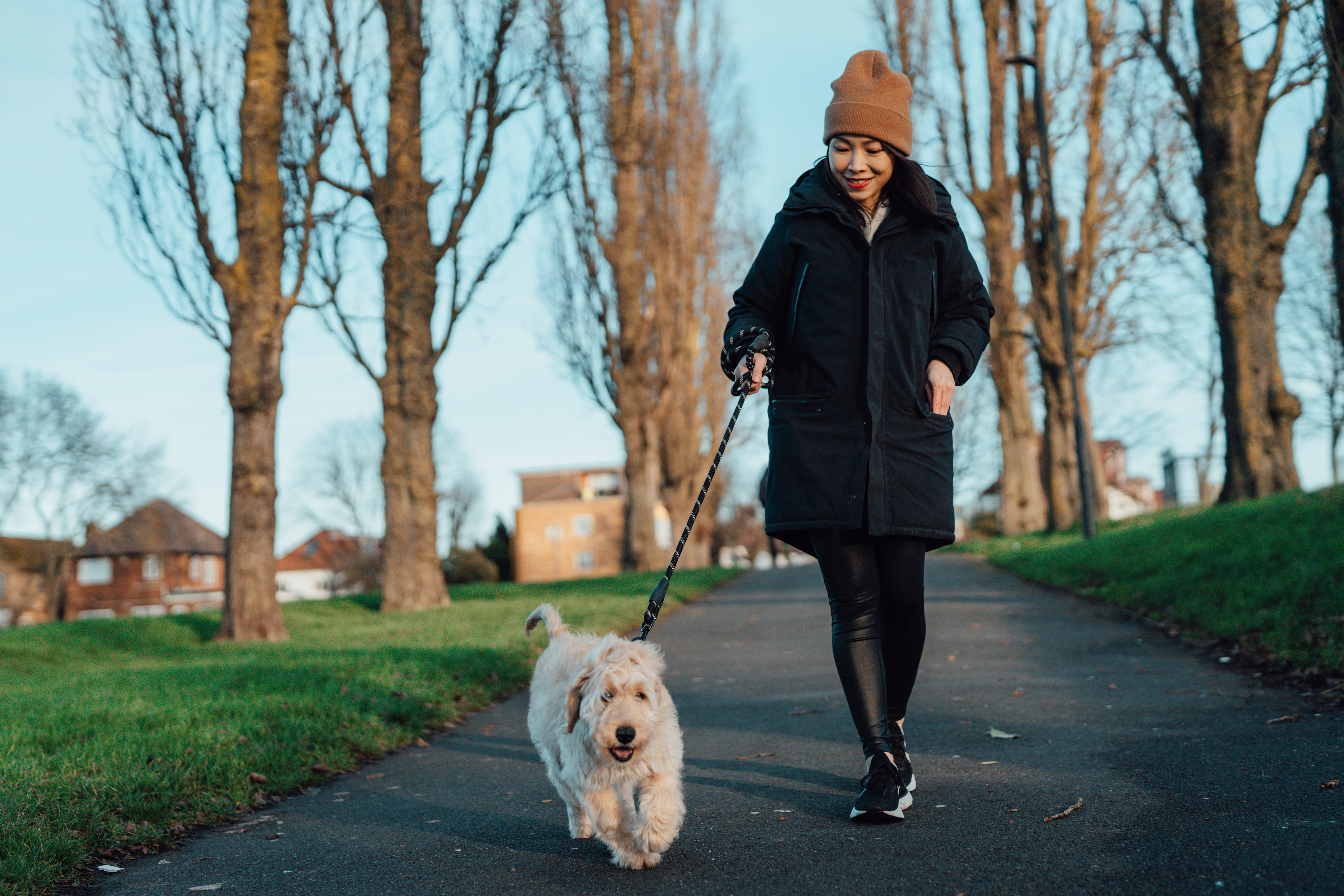 Woman walking her dog in a park, both looking content