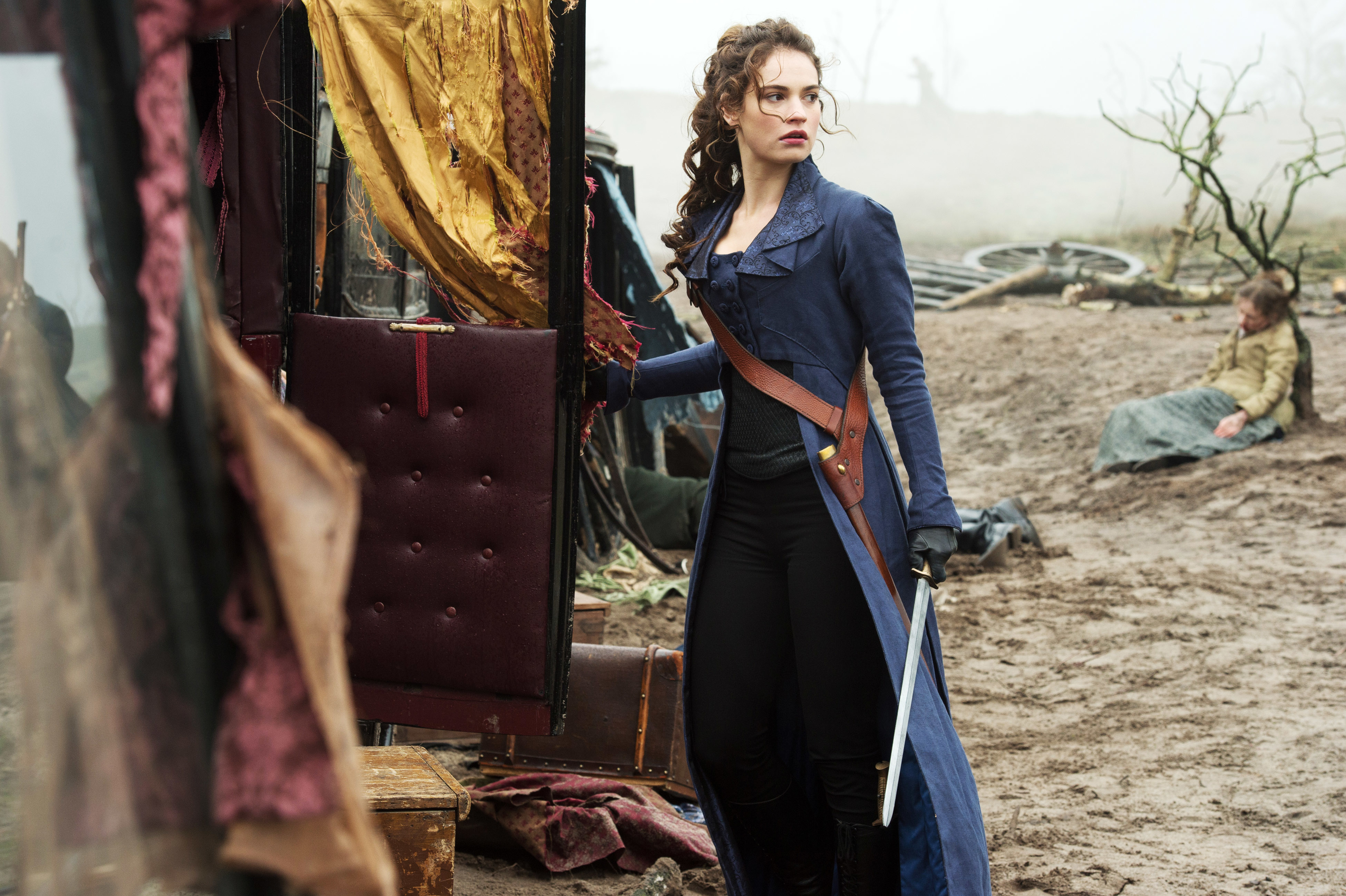 Woman in period costume with sword stands by carriage, tense scene with person on ground