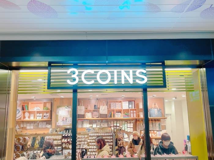 店の入り口に「3COINS」と書かれた看板があり、店内はアクセサリーや雑貨で賑わっています。