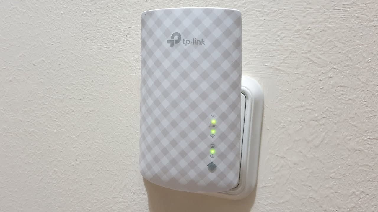 TP-Link range extender plugged into a wall socket with signal strength indicator lights on