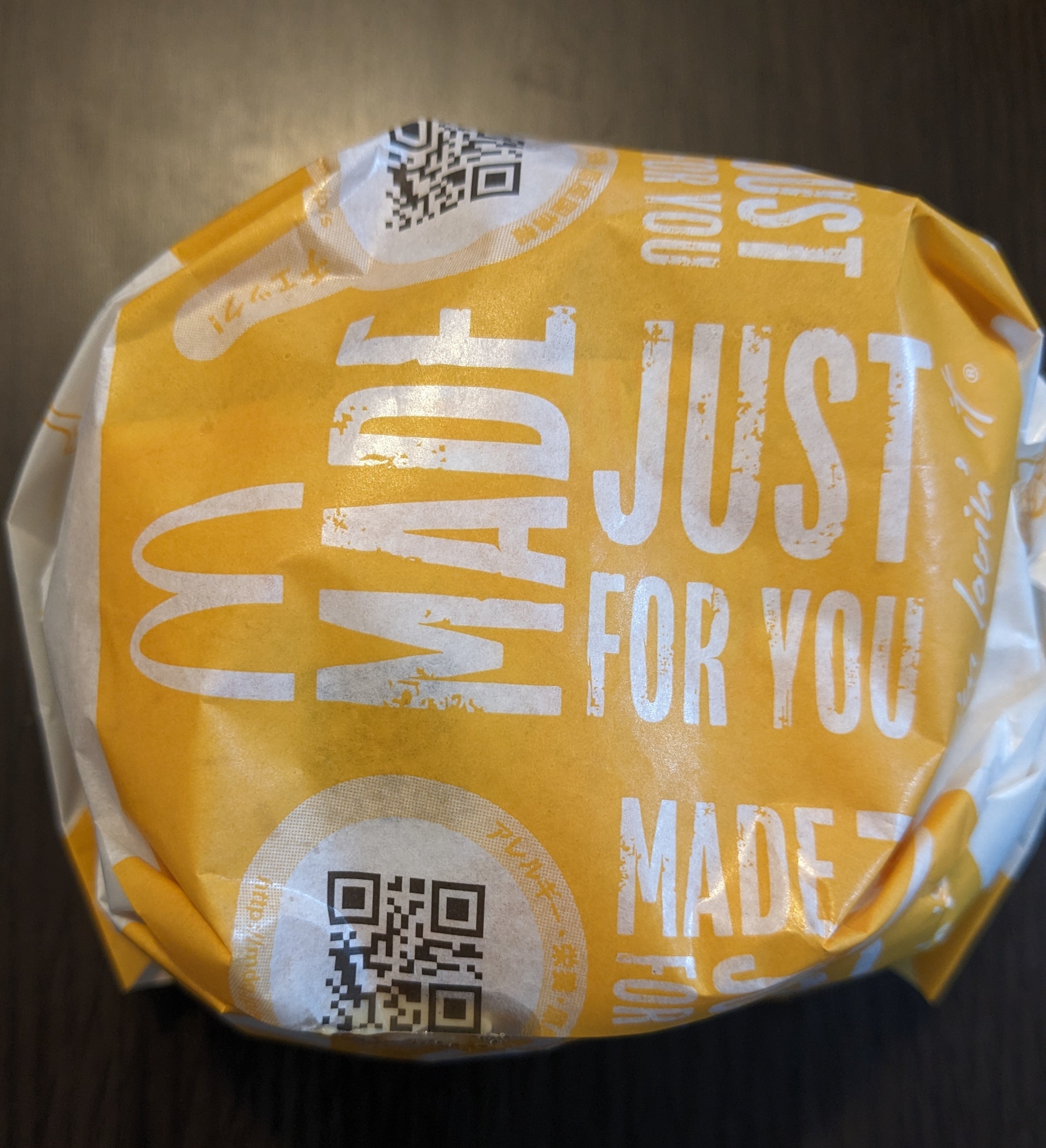 マクドナルドの商品がテーブルの上にあり、包装紙にはQRコードが印刷されています。