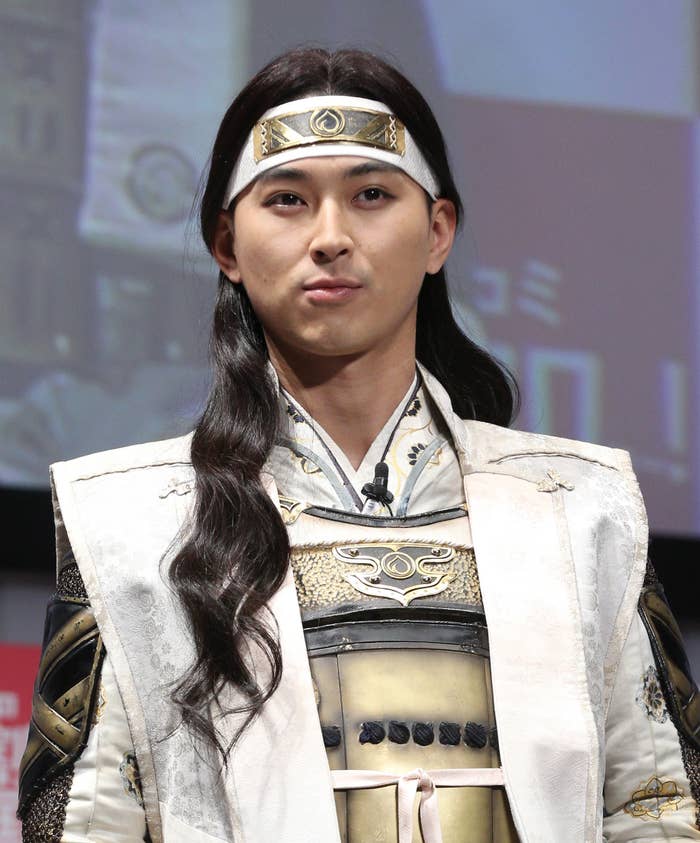 人物が伝統的な装飾を施した衣装を着用し、頭には装飾的なバンドをしています。