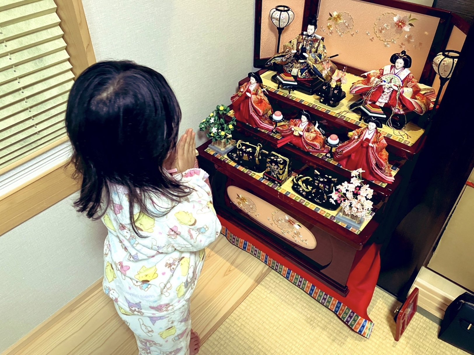 女の子がひな祭りの雛人形を見ている。