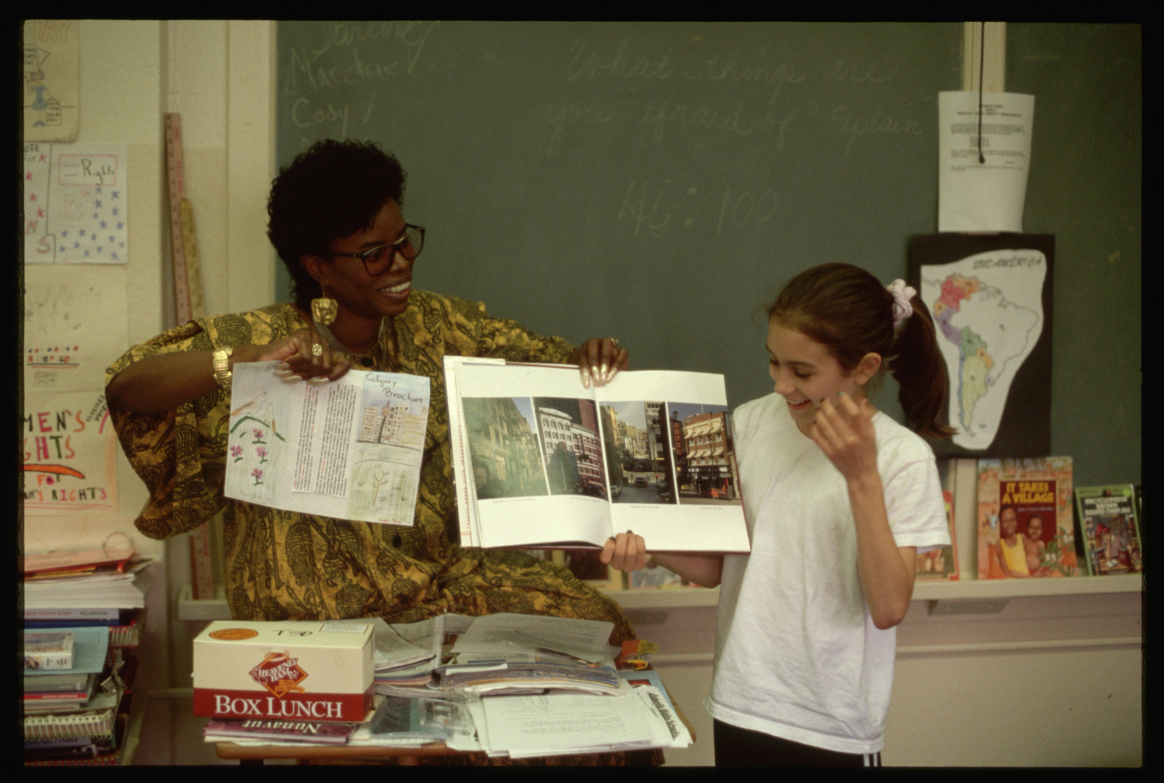 Teacher showing a book to a student in a classroom