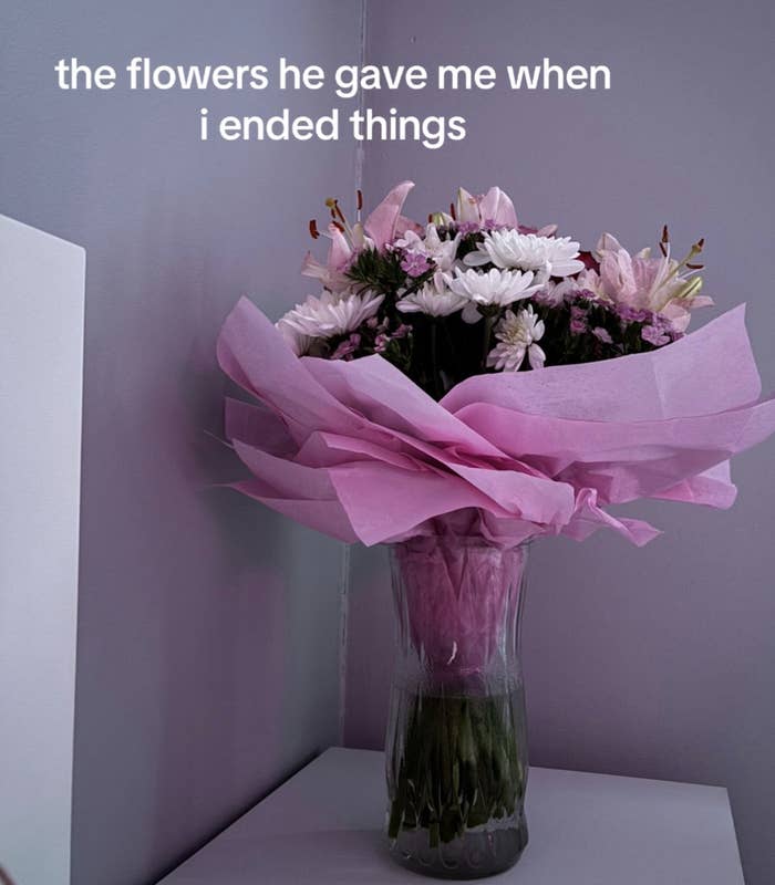 Bouquet of mixed flowers in vase on corner shelf, with text overlay "the flowers he gave me when i ended things"