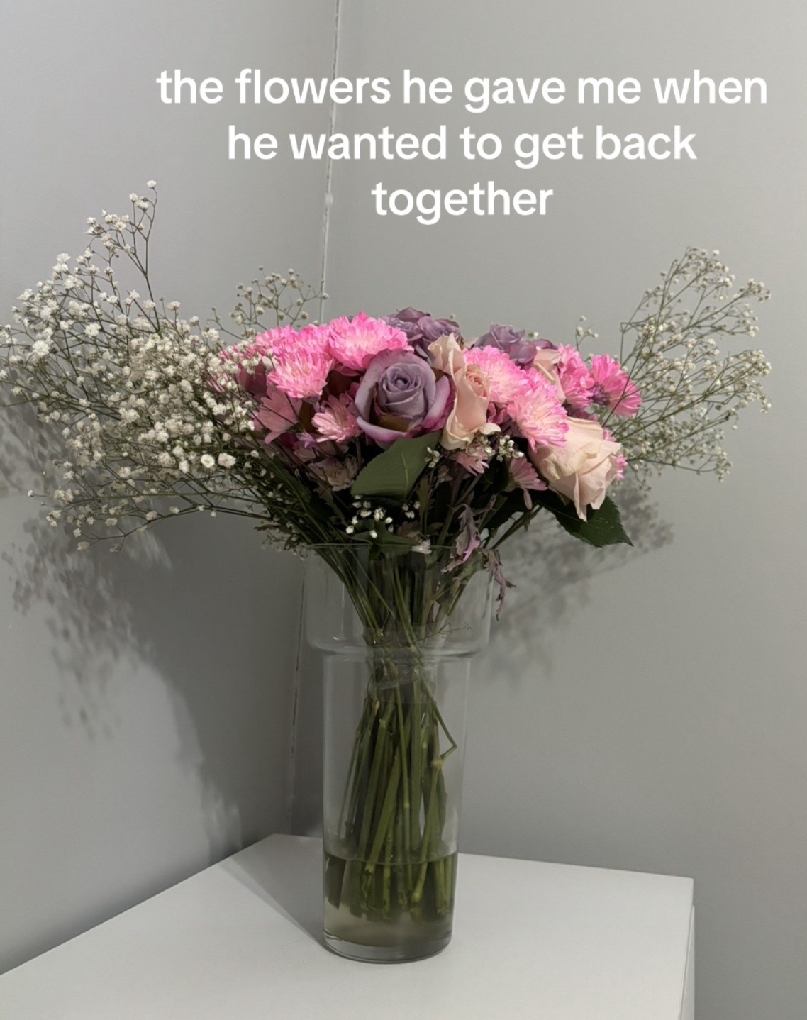 A vase with flowers on a table, text above reads "the flowers he gave me when he wanted to get back together."