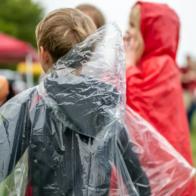 Child models in rain ponchos at an outdoor event