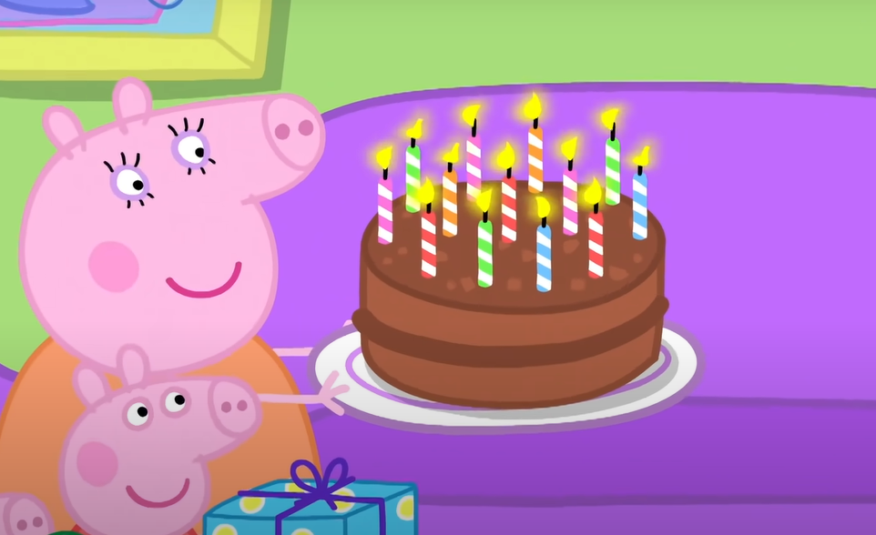 Peppa Pig and George with a birthday cake with lit candles