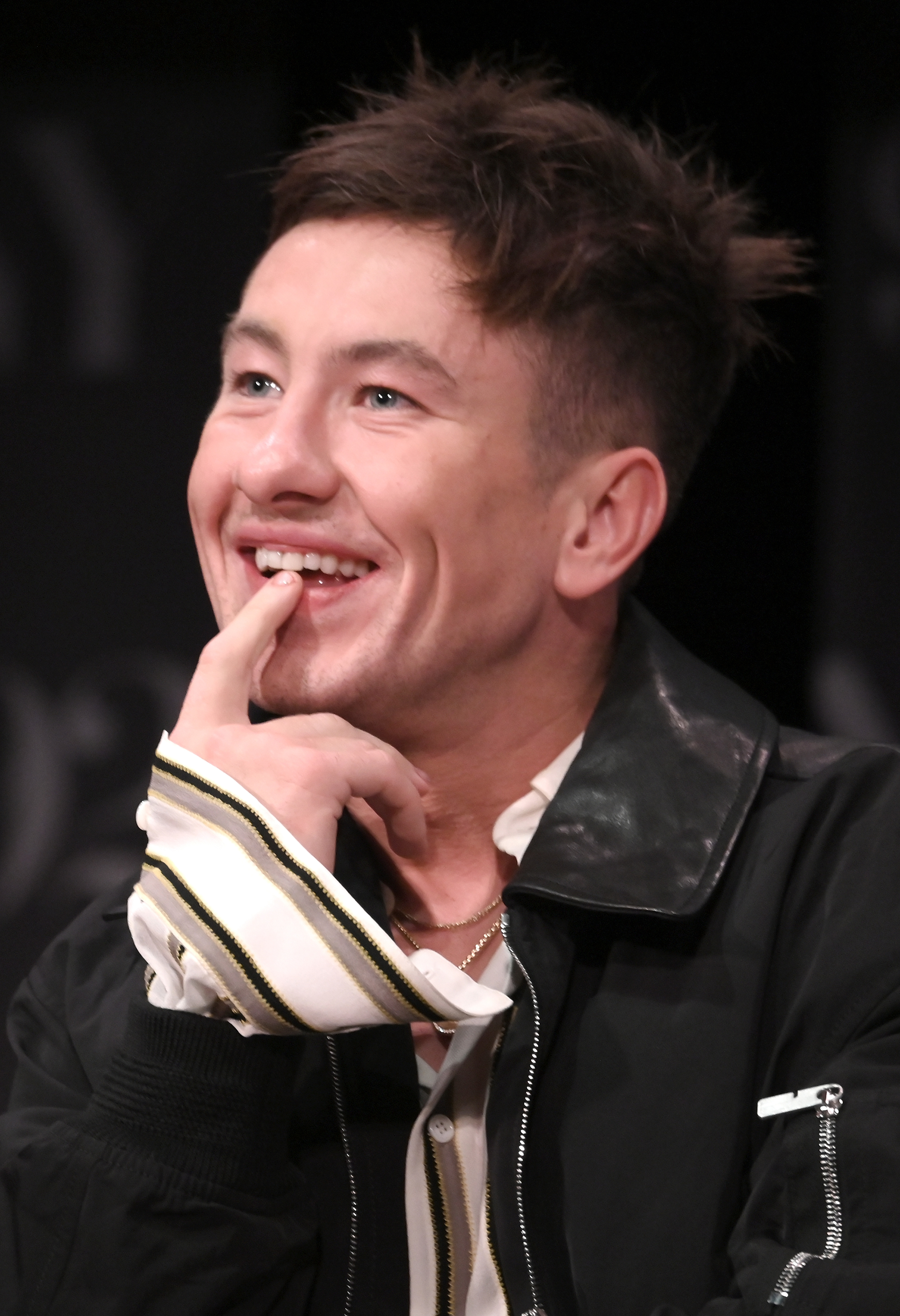 Barry smiling at an event, wearing a light jacket with