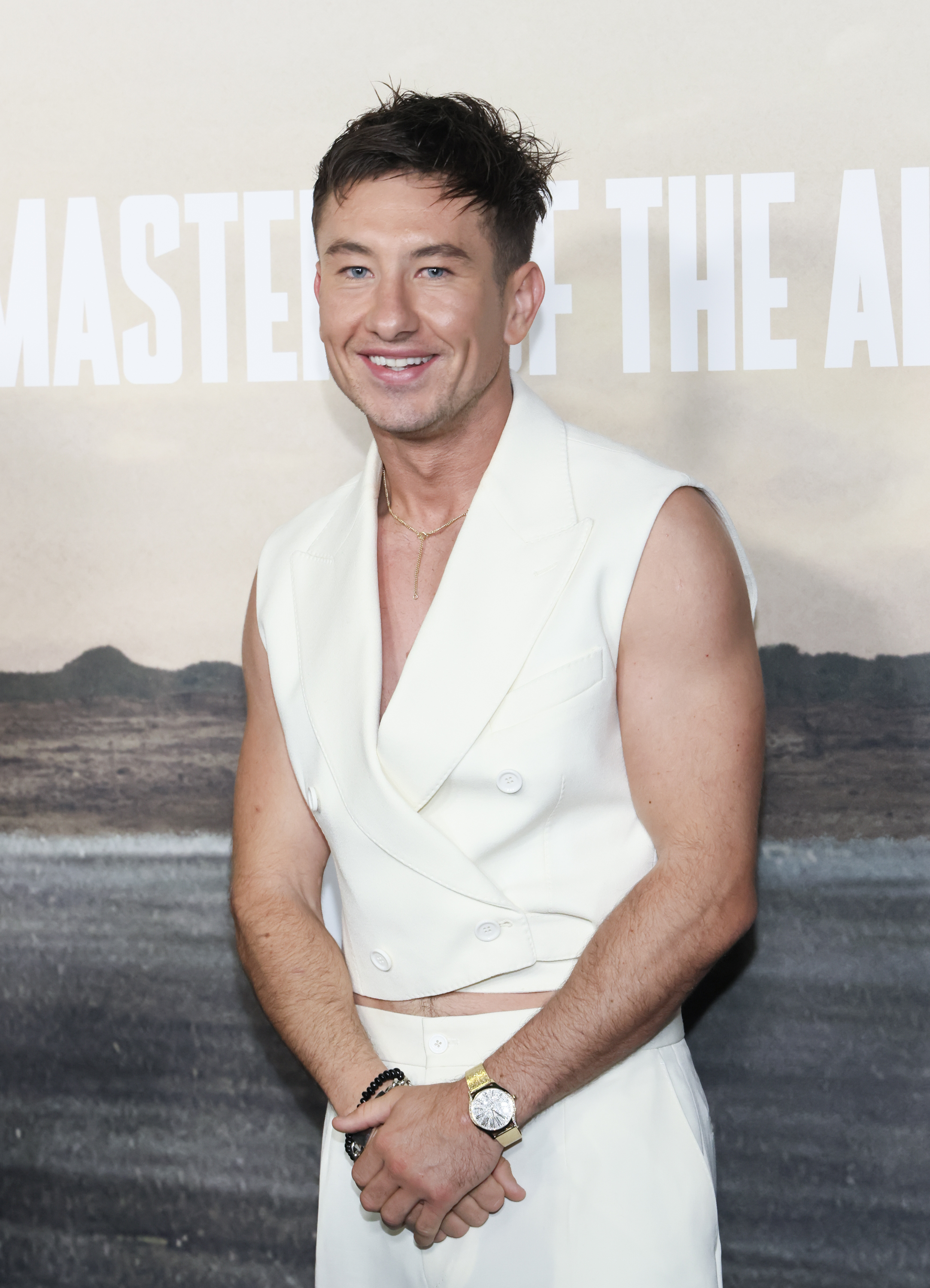 Barry Keoghan in a sleeveless jacket and trousers, posing with hands clasped at a premiere