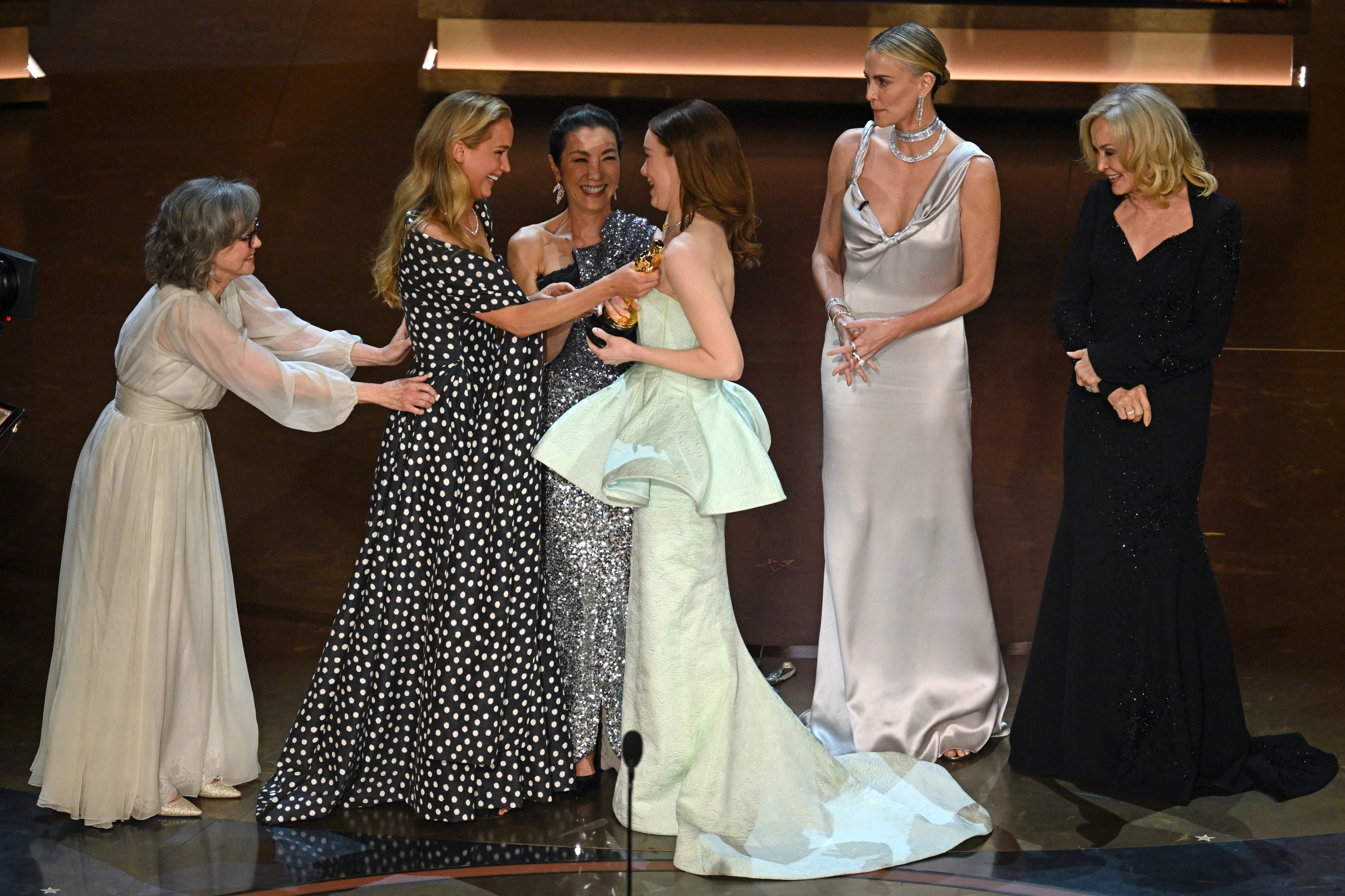 Emma Stone accepting her Oscar the other five past winners