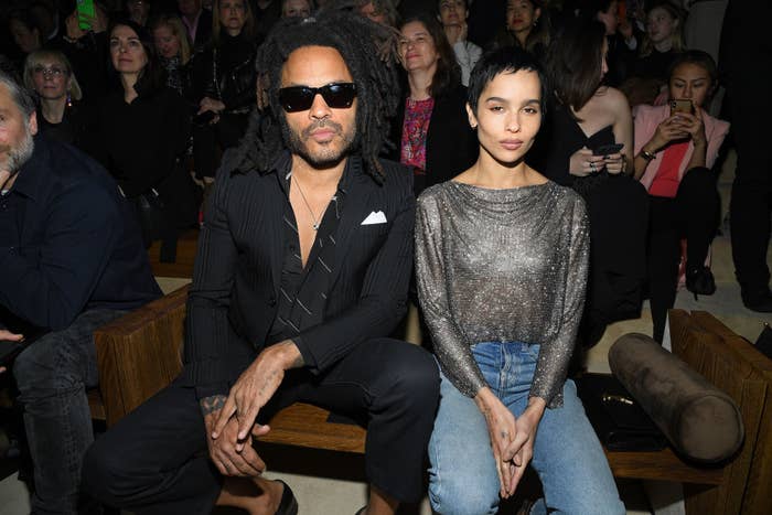 Lenny and Zoë Kravitz sitting front row at an event, one in a pinstripe suit, the other in a glittery top and jeans