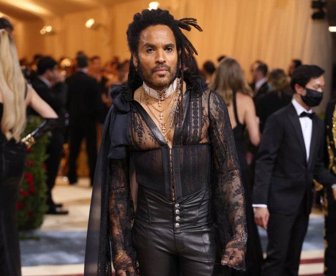 Lenny Kravitz in a sheer lace top, leather pants, and a cape on the red carpet