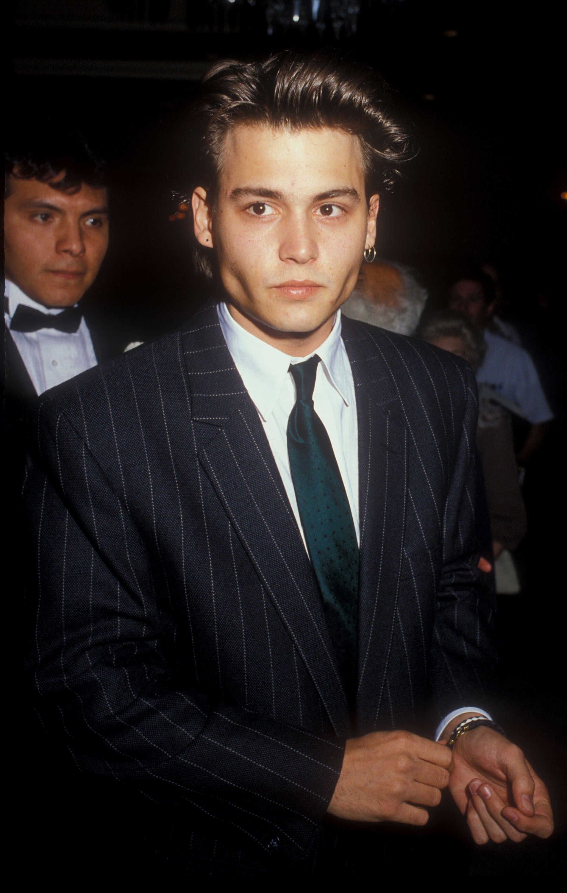 Johnny Depp in a pinstripe suit with a teal tie at an event